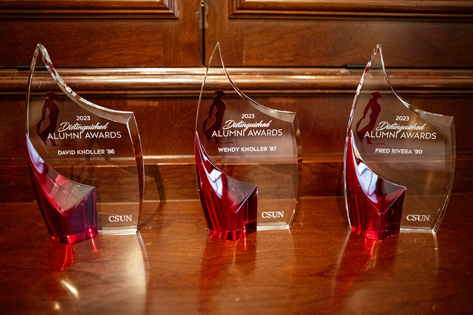 Three clear glass awards with the honorees' names engraved on them
