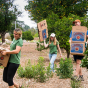 Three people carry cardboard boxes in CSUN's Orange Grove
