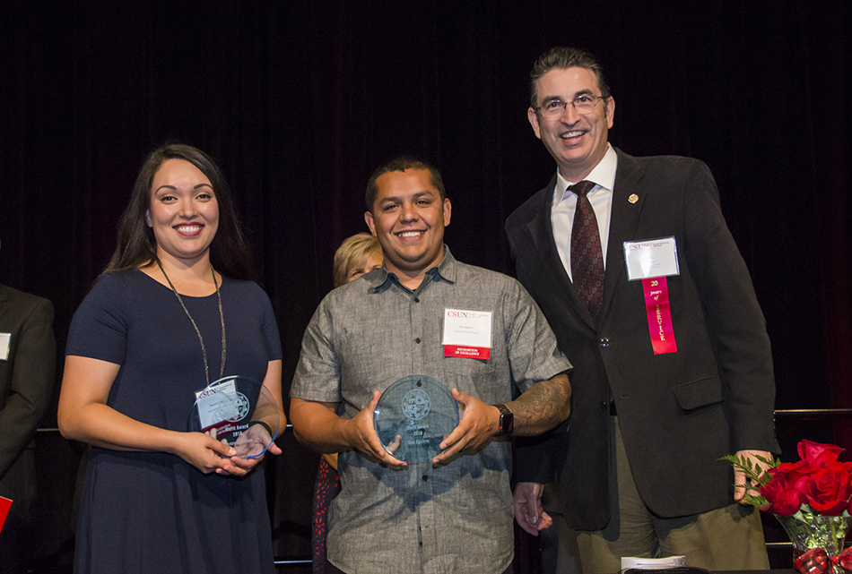 Vanessa Ochoa and Noe Aguirre, pose with their CSUN Merit Awards alongside Rick Evans.