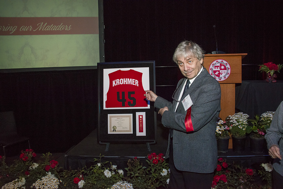 William Krohmer points at his framed No. 45 CSUN basketball jersey.
