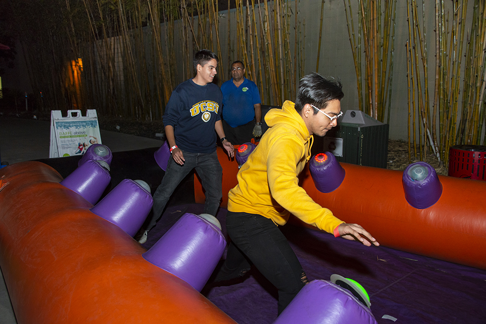 Two male students in an inflatable obstacle course.