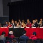 Nearly two dozen members of the CSUN President search committee sit in two rows at a public forum.
