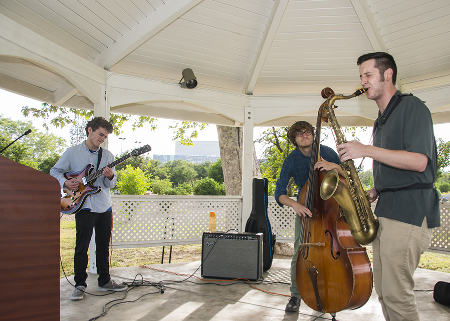 A saxophonist, stand-up bass player, and guitarist play in a gazebo at the Orange Grove Bistro.