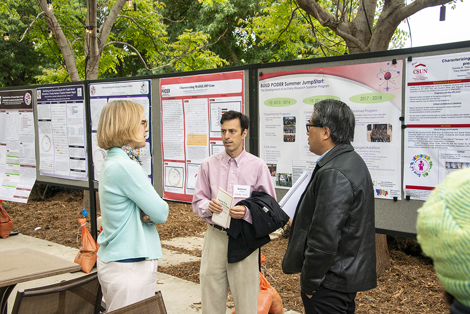 Three CSUN faculty talk by poster presentations at the Orange Grove Bistro.