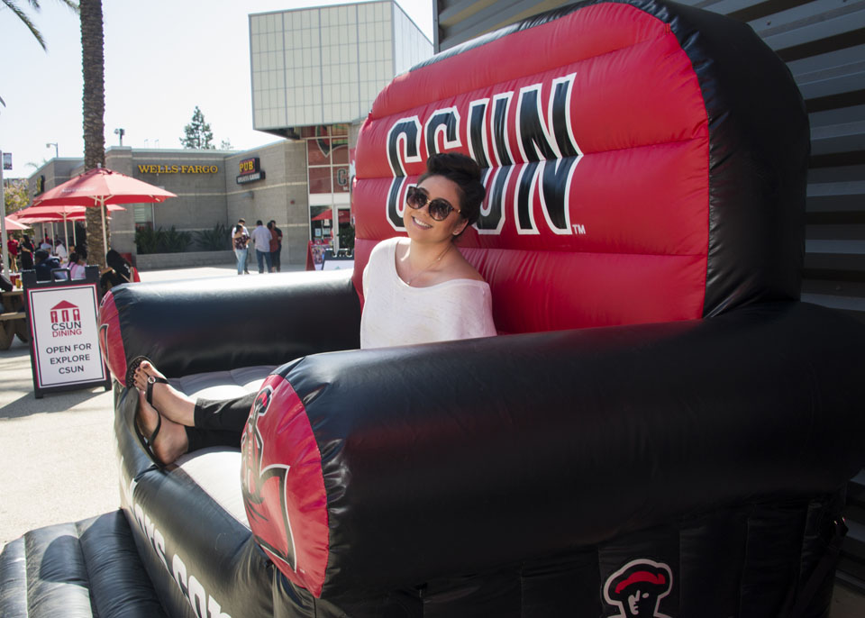 Incoming student sits in an inflatable CSUN chair in the University Student Union.