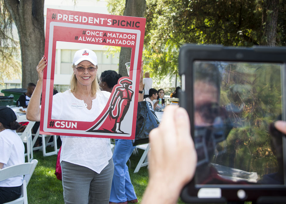 CSUN President Dianne F. Harrison holding a social media frame for a photo.