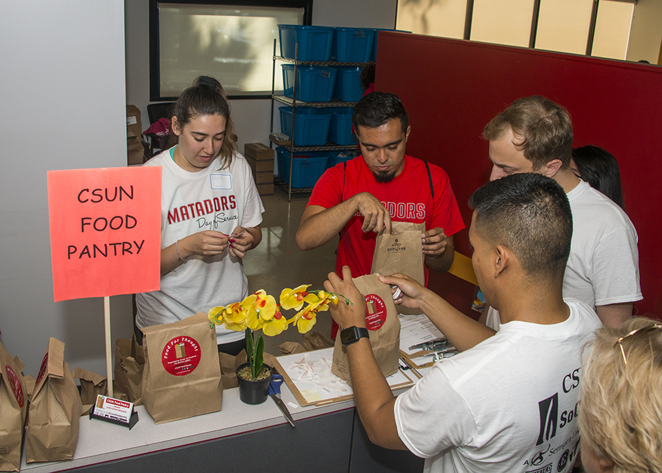 Volunteers placing food into food pantry boxes.