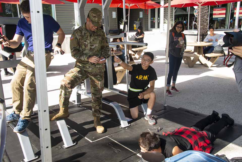 A student veteran coaches students doing military push-ups on the CSUN Plaza del Sol.