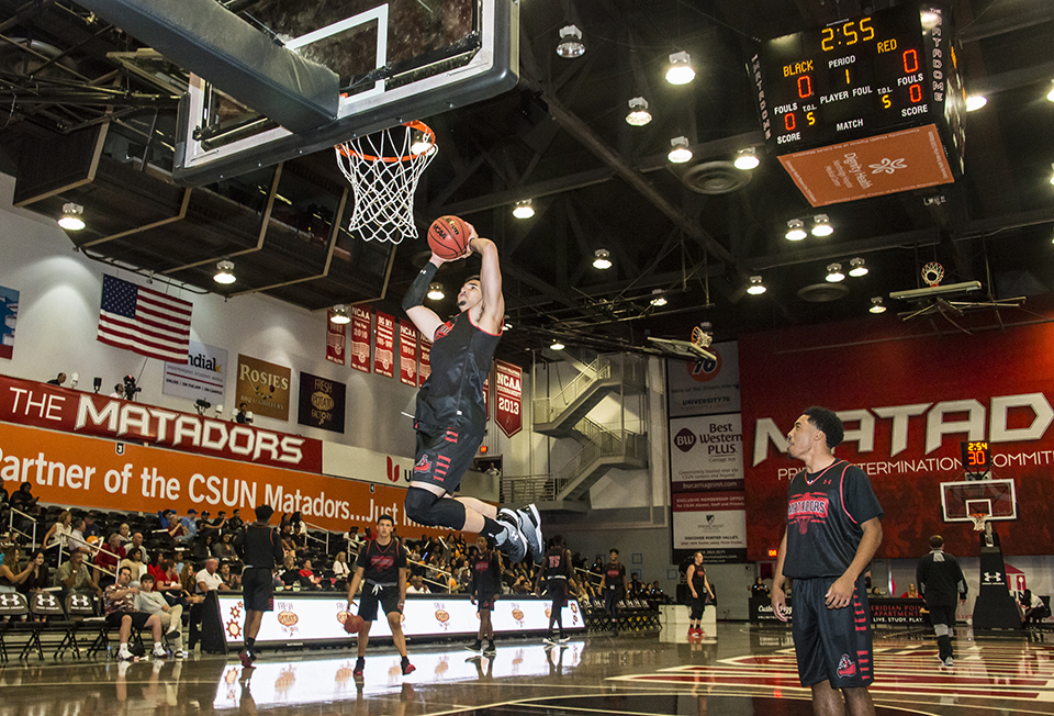 CSUN men's basketball player goes in for a dunk.