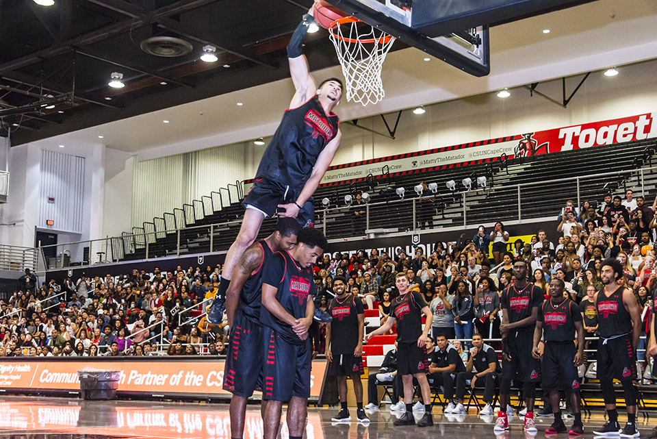 Kobe Paras leaps over 2 teammates for a dunk.
