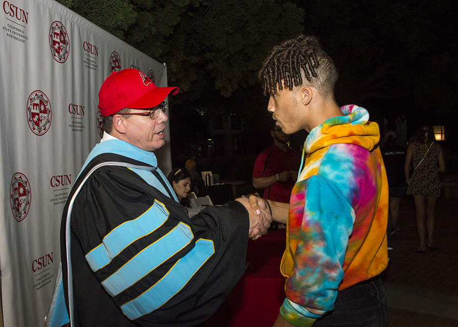 Wayne Maines shakes the hand of a CSUN student.
