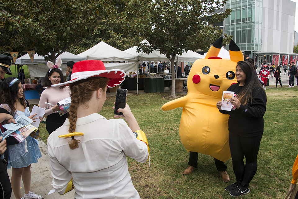 Woman takes photo of Pikachu and attendee