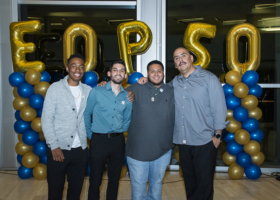 Four men stand in front of an EOP 50 balloon display.