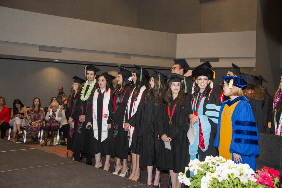 Graduates lined up in front of stage