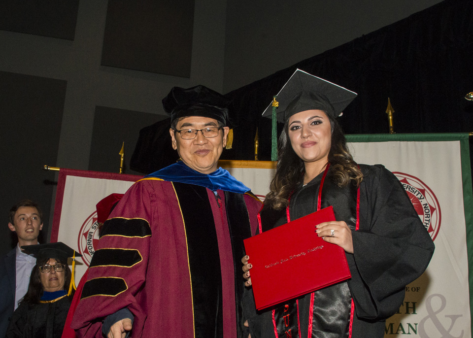 Provost Yi Li and graduating student holding diploma