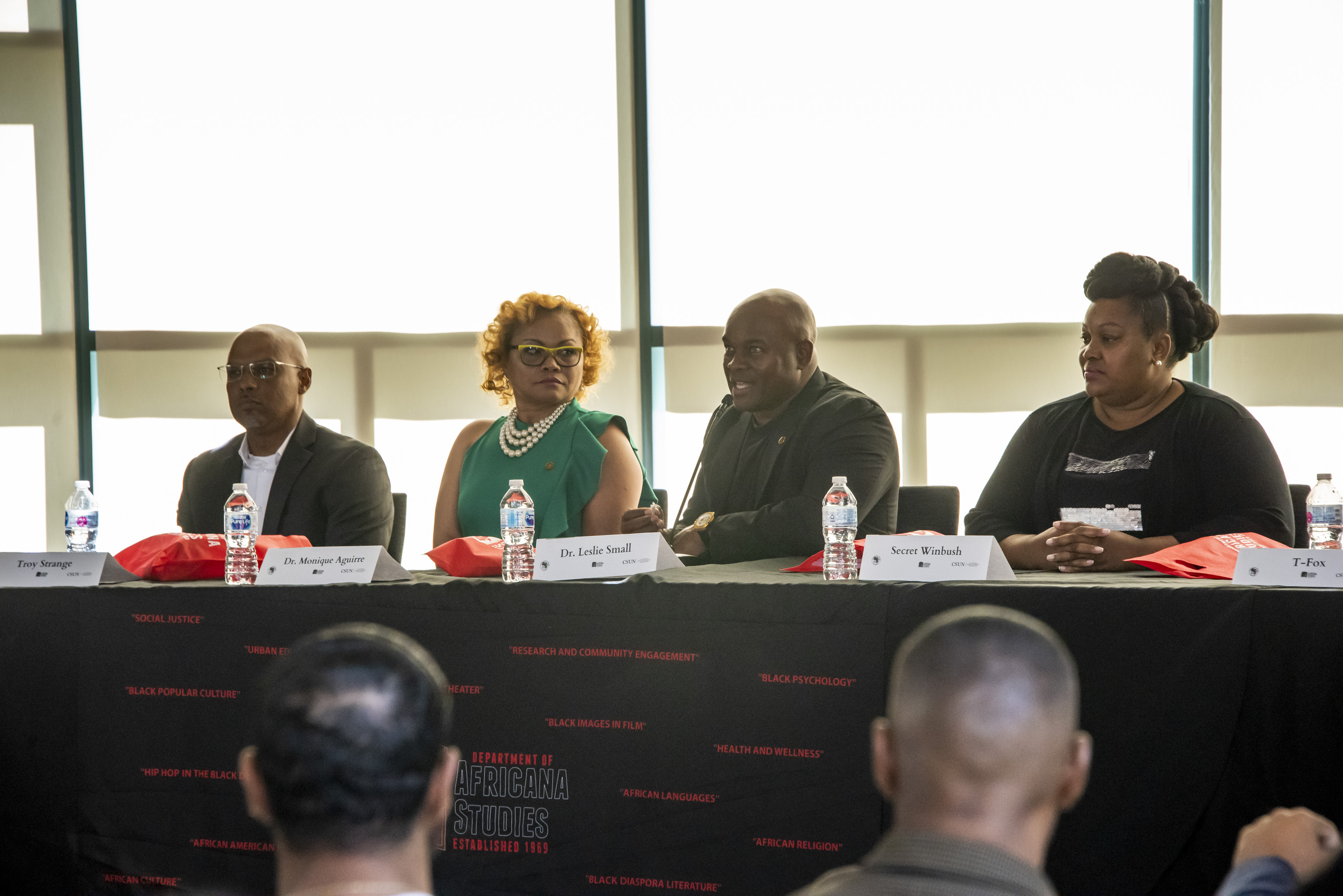 A panel of CSUN Africana studies faculty and alumni sit at a table during an event.