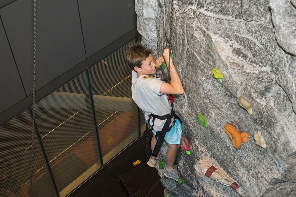 Kid climbs on rock wall