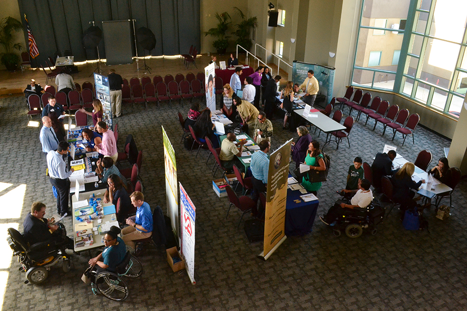 Several booths with representatives from federal agencies speaking with student in the Grand Salon at CSUN.