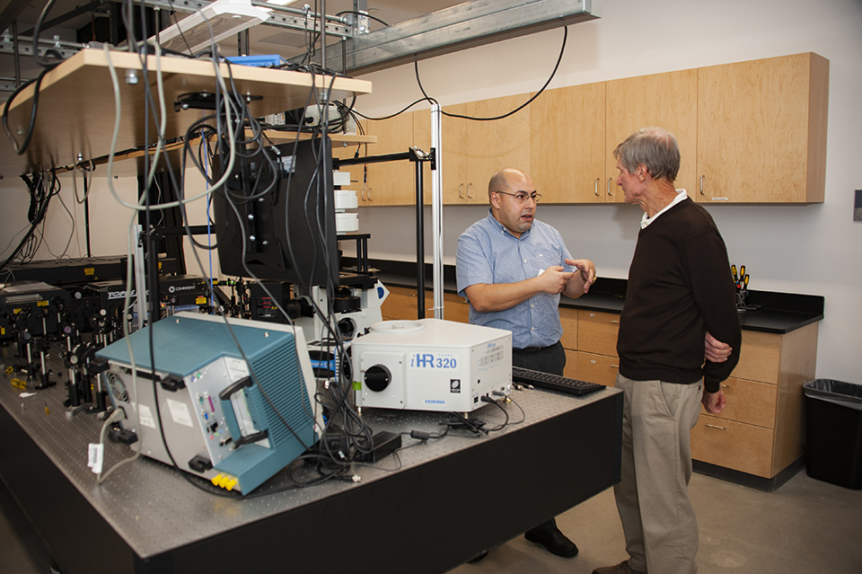 Professor Aziz Boulesbaa, left, shows off his laser lab.
