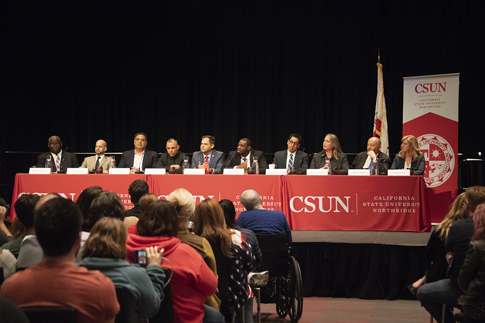 Ten candidates for the District 25 U.S. Congressional seat are seated at a CSUN table for a forum hosted by CSUN and College of the Canyons.