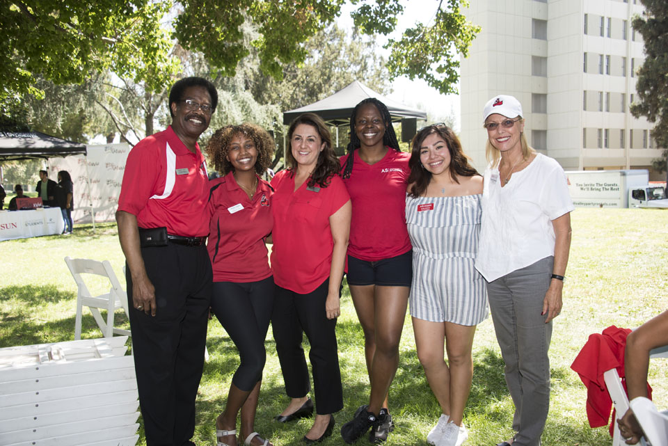 Vice President for Student Affairs William Watkins and CSUN President Dianne F. Harrison taking a photo with student volunteers.