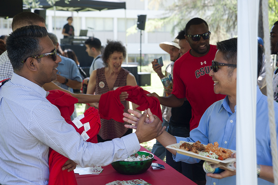 Two CSUN employees greet each other across the buffet line at the President's Picnic.