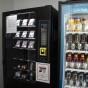 A wellness vending machine full of health care items sits next to a machine with beverages.