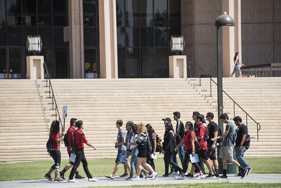 Group of students walk by the library.
