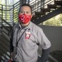 Portrait of Cesar Jacinto, custodian, in a stairwell, wearing a CSUN face mask.