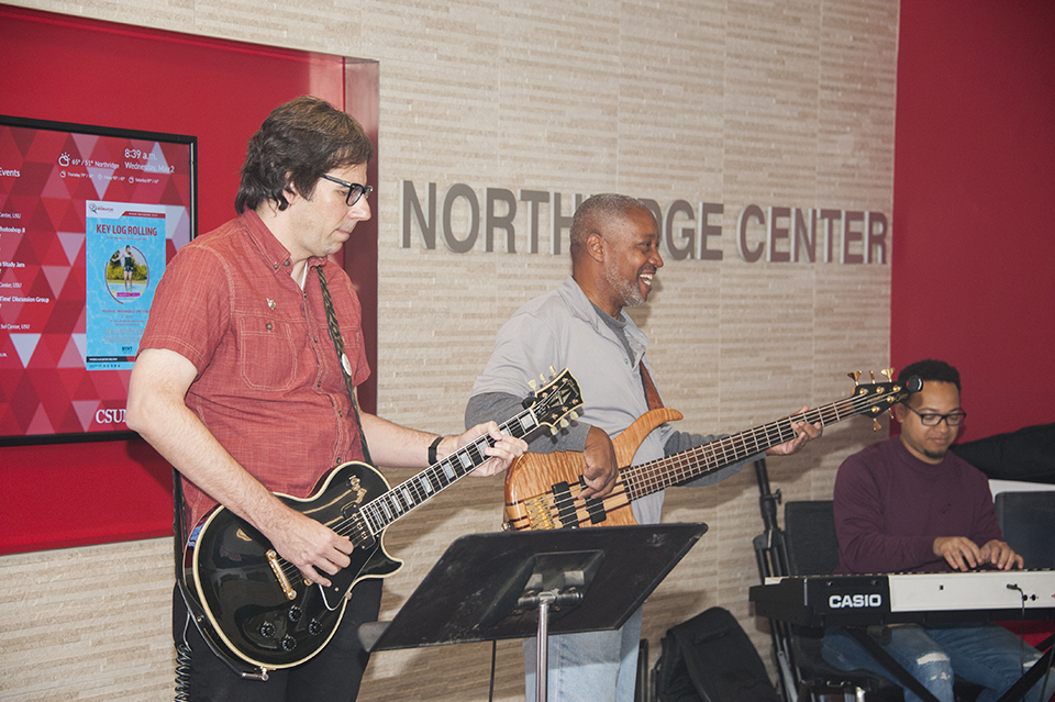 Two guitarists and a keyboardist play in the Northridge Center lobby.