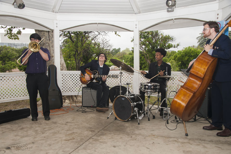 Musicians playing upright bass, drums, guitar and trumpet.