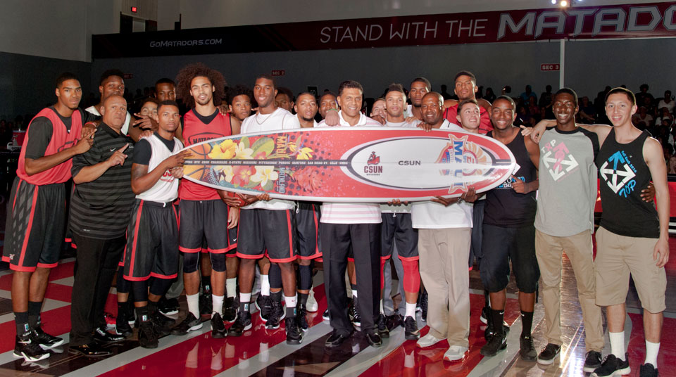 Basketball team holds surfboard.
