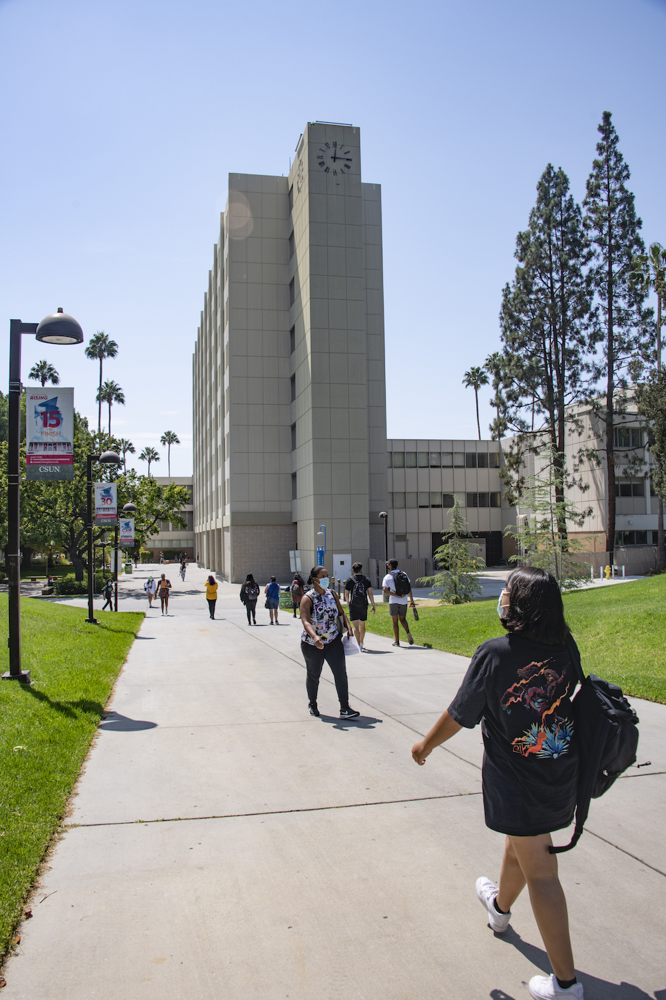 Several students walking with Sierra Tower in background