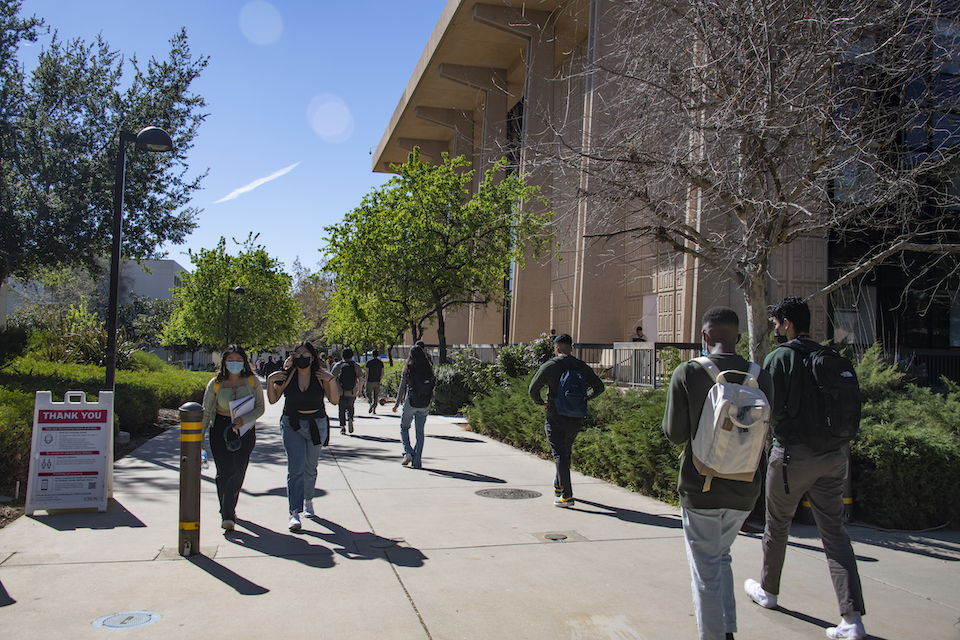 Students walking on sidewalk near University Library