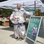 Man with plastic bags filled with trash attached to his body.
