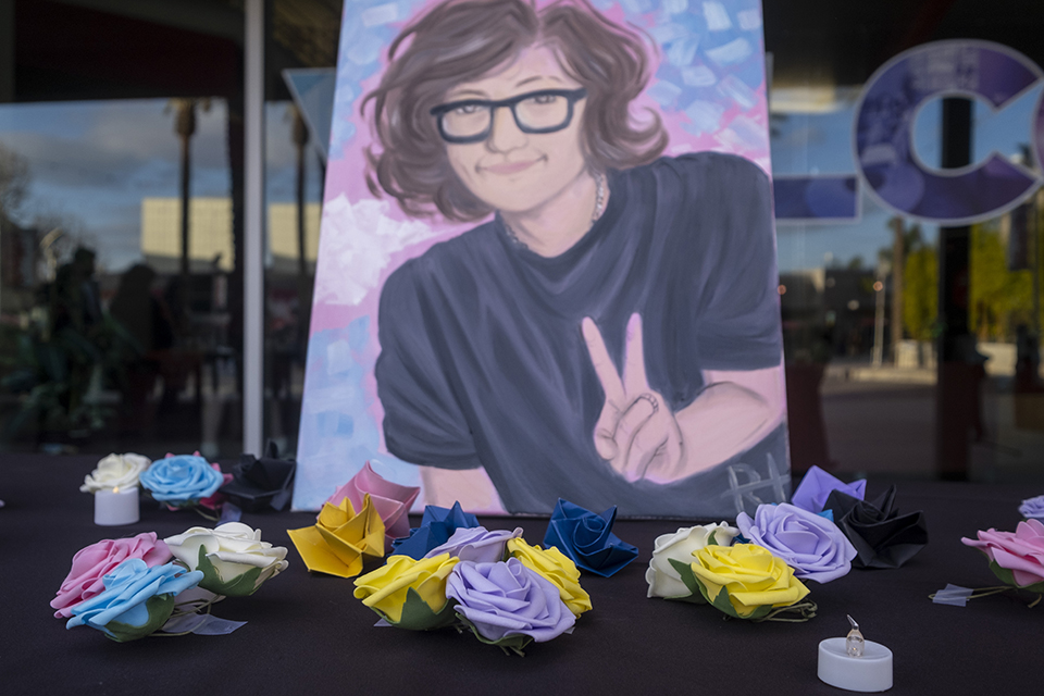 Origami flowers in front of a painted portrait of teen Nex Benedict