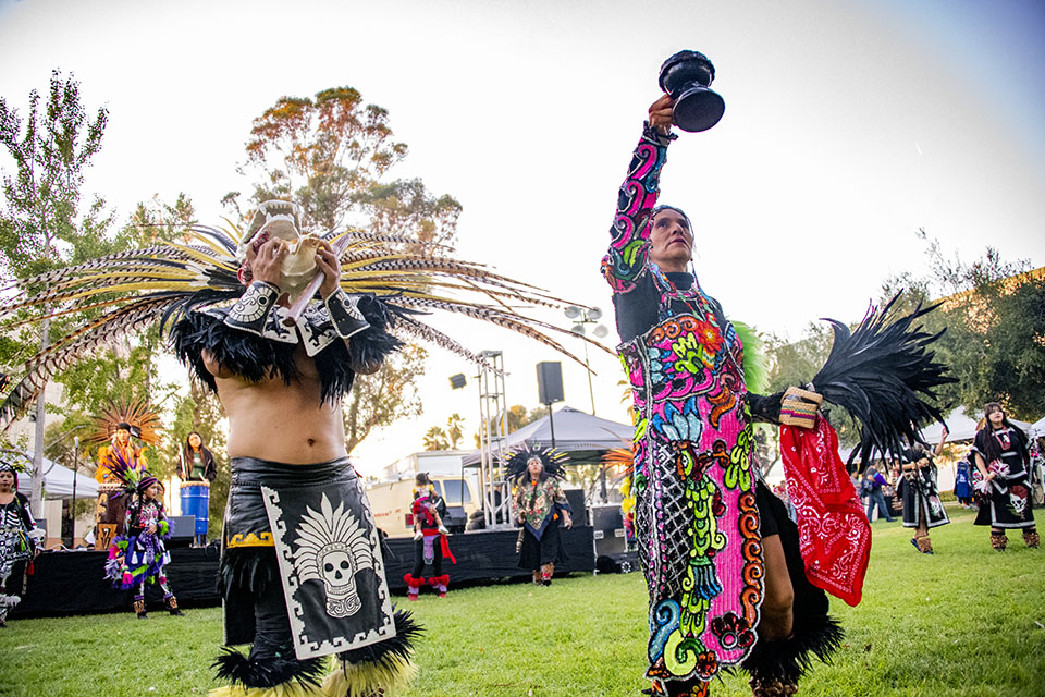 Dancers in traditional folklorico (folk dancing) costumes perform on the Chicano House Lawn.