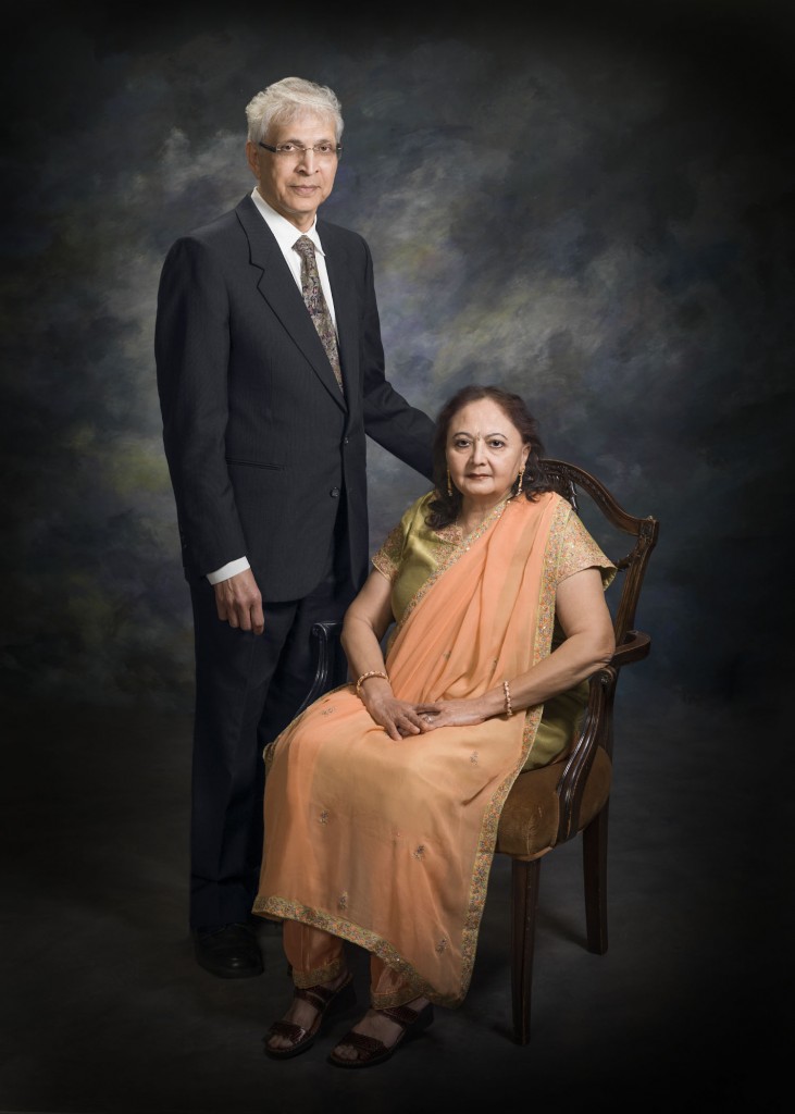 Studio portrait of Drs. Jasvant Modi and Meera Modi. Javant Modi is standing beside his wife Meera Modi who is seated.