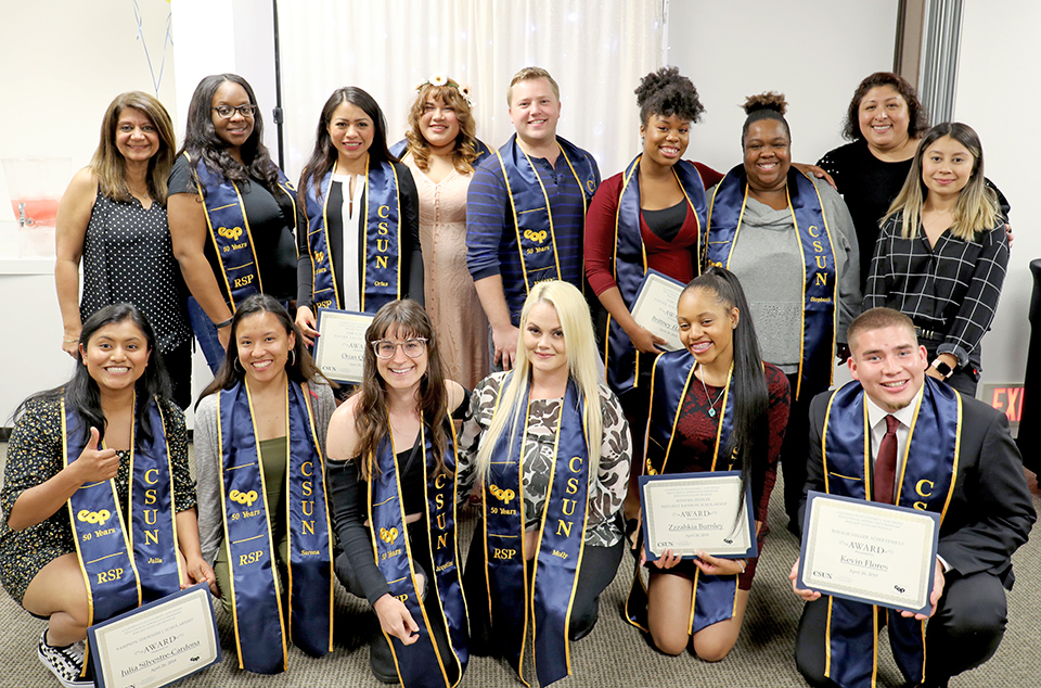 EOP Resilient Scholars Program graduates, wearing colorful EOP commencement sashes, pose for a group photo.