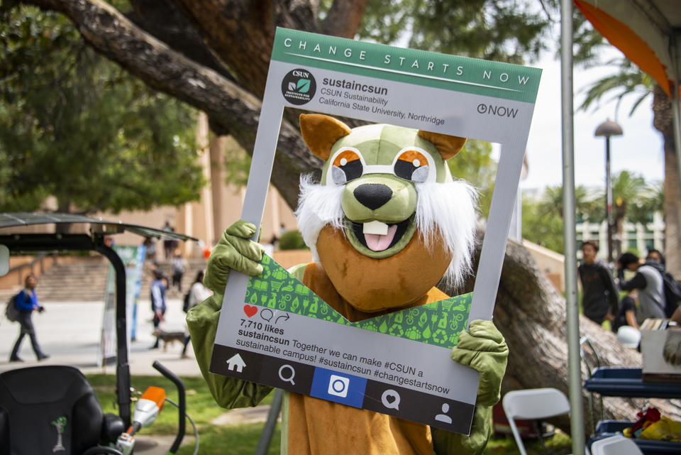 Person in squirrel costume posing holding an Instagram frame.