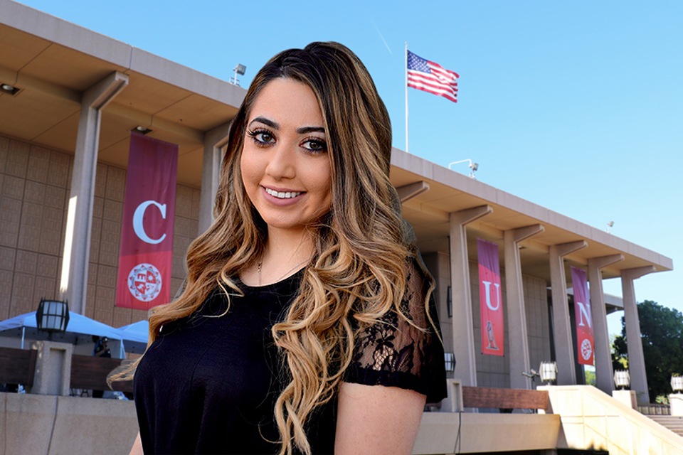 A female CSUN student poses in front of a virtual CSUN Library background.