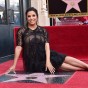 Eva Longoria sits down and poses with her Hollywood star.