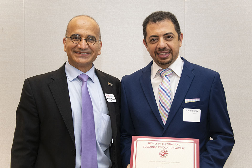 Houssam Toutanji and Peter Bishay standing together. Bishay holds award certificate.