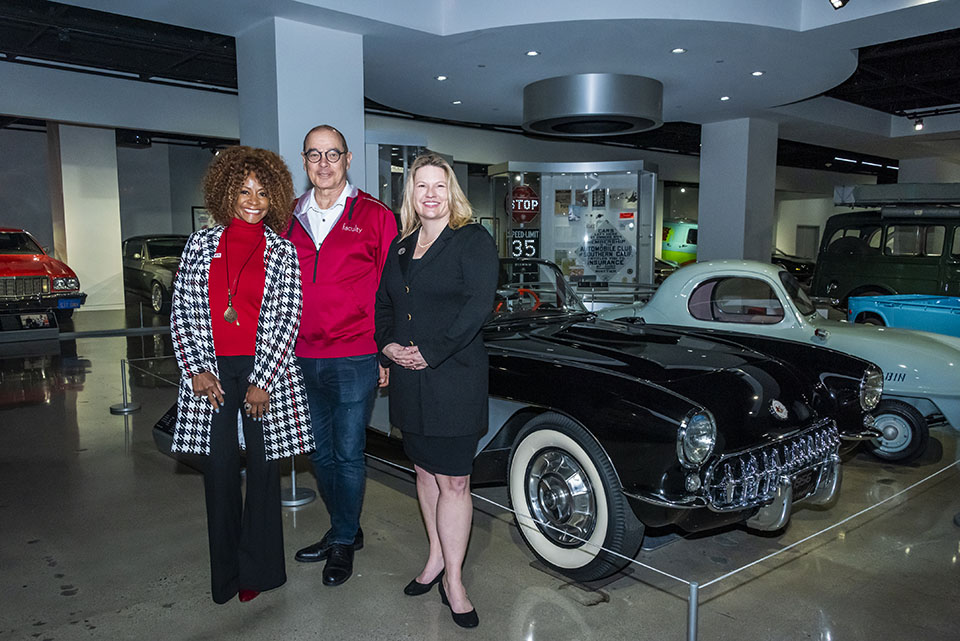 Theresa White, Michael Neubauer and CSUN President Erika D. Beck stand in front of restored vintage car