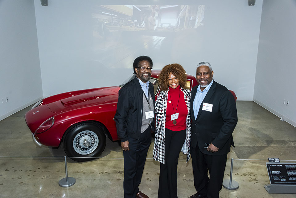 William Watkins, Theresa White and Cedric Hackett pose in front of red sports car.