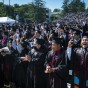 Graduates in caps and gowns cheer