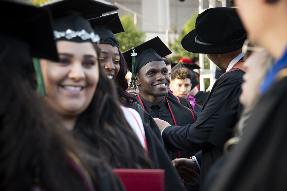 A happy CSUN graduate is greeted by another man at CSUN commencement.