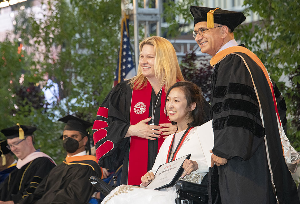 President Erika D. Beck and Houssam Toutanji, dean of the College of Engineering and Computer Science, stand behind Megan Ngo, the 2022 Wolfson Scholar, at Honors Convocation 2022.