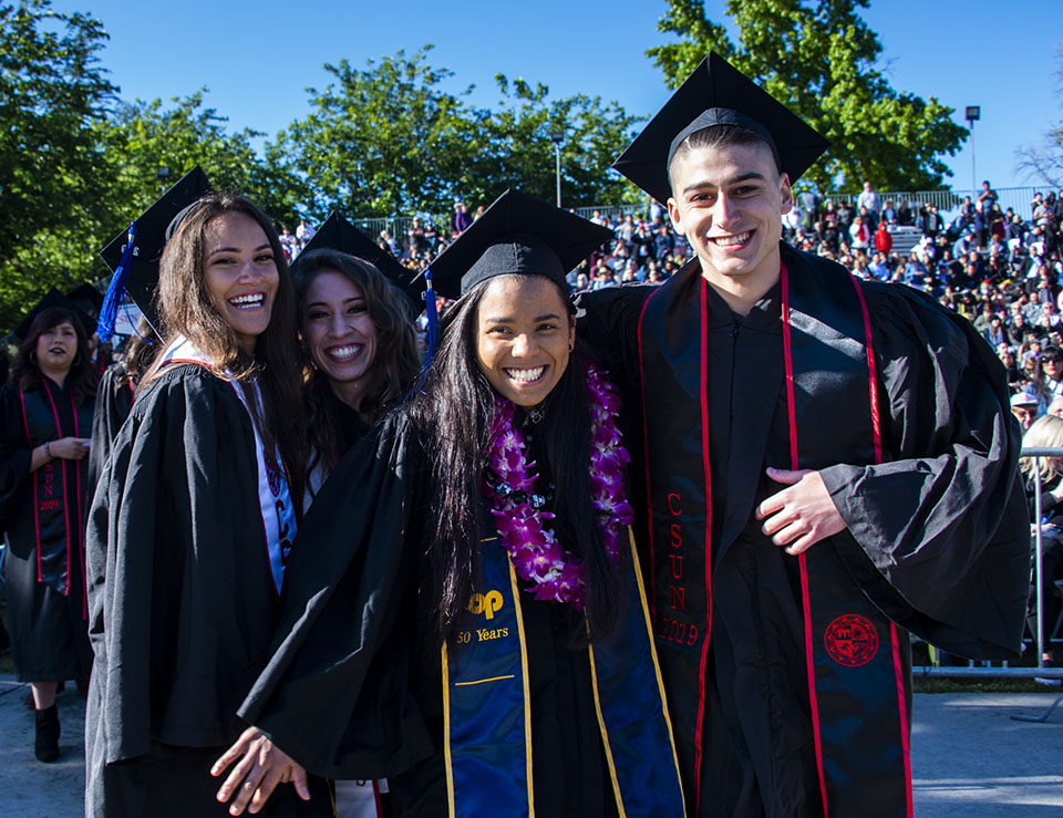 Two pairs of CSUN graduates get close for a photo.