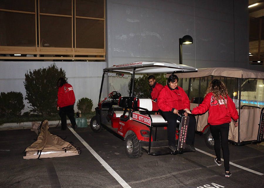 Safety escorts prepare the patrol cart for the night's shift.